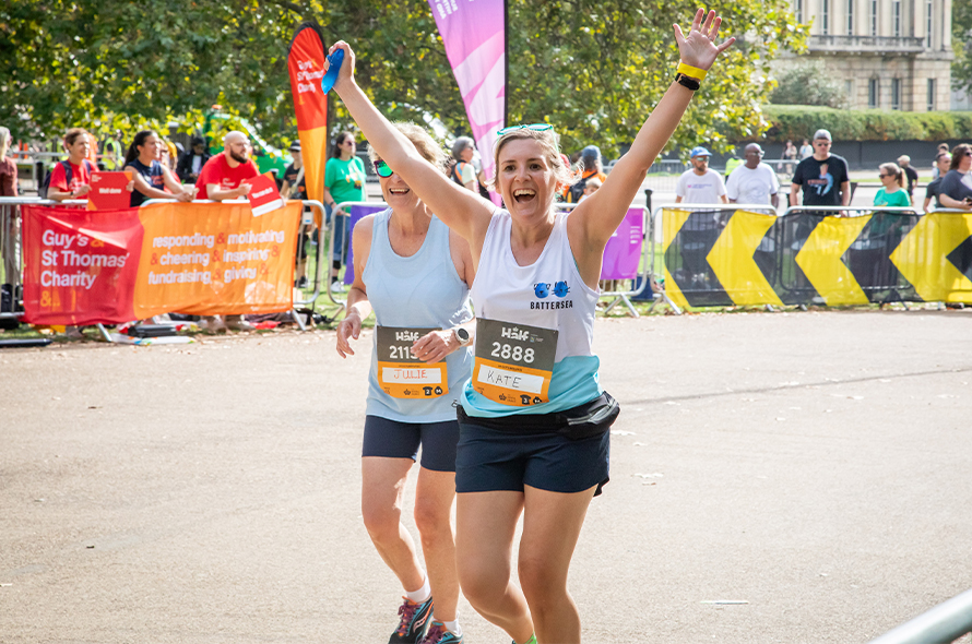 Woman cheering with her arms in the air whilst running