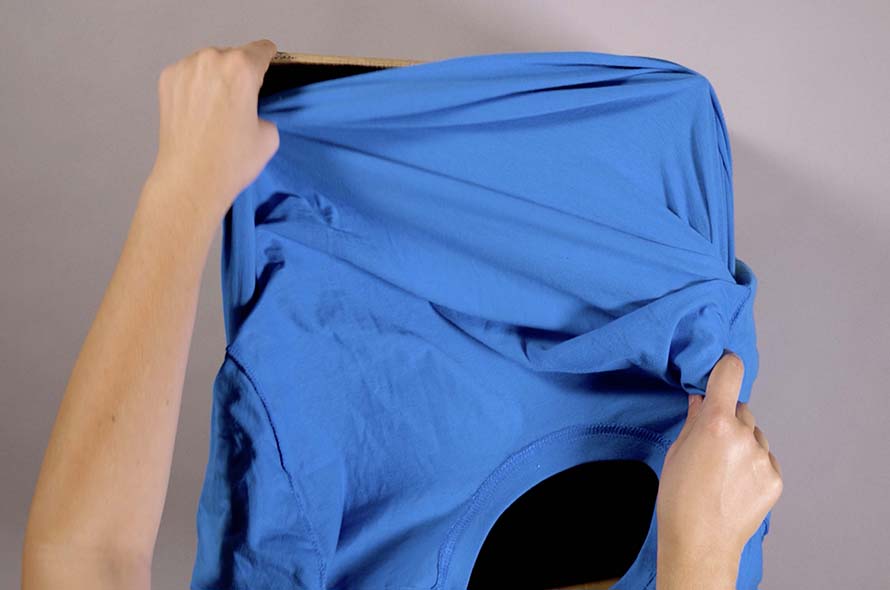 A t-shirt being adjusted around a cardboard box