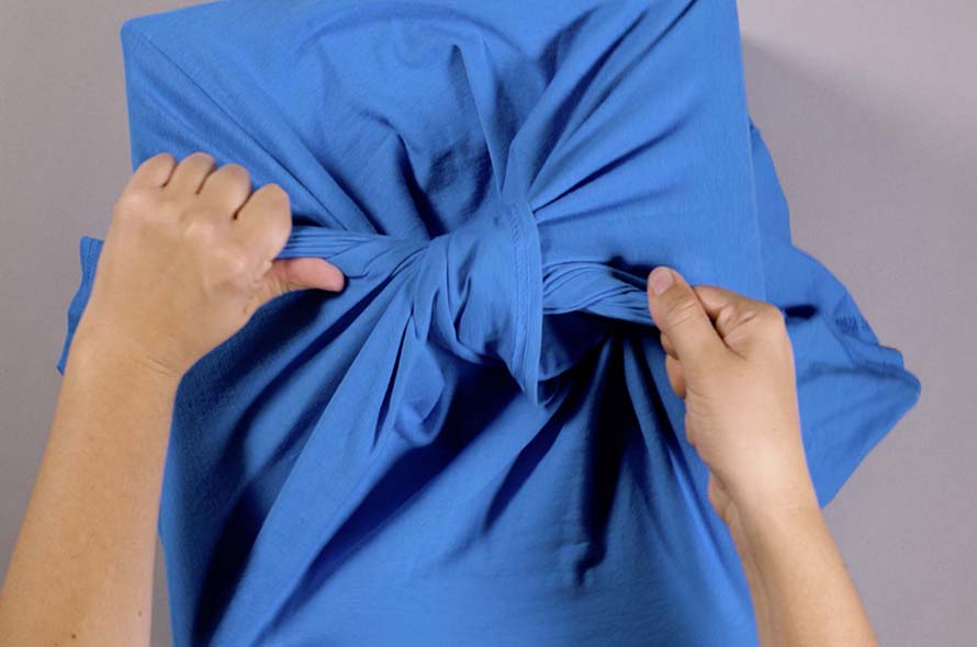 A t-shirt being tied around a cardboard box