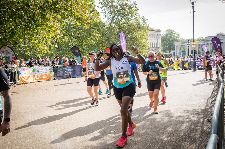 Woman smiling and cheering whilst running