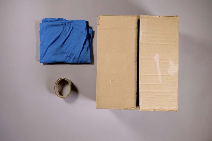 A cat hideaway made using a t-shirt and a cardboard box